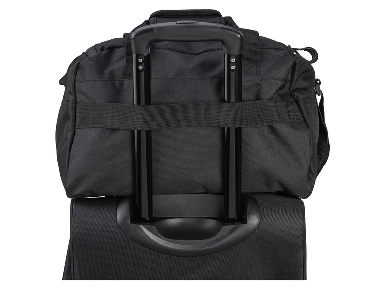 Ein schwarzer Rollkoffer, der an einer Reisetasche befestigt ist.