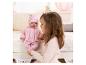 Mädchen spielt mit einer Baby Annabell Puppe in rosa Schlafanzug und Jacke.