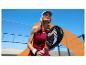 Frau mit Padel-Schläger in Sportkleidung auf sonnigem Außenplatz.