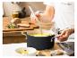 Eine Person schöpft Suppe aus einem KitchenAid-Topf in eine Schüssel.