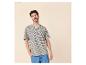 Mann in beige-marineblau gestreiftem T-Shirt, blauen Jeans, Hand in der Tasche.