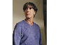 Mann in einem blauen Pullover mit V-Ausschnitt.