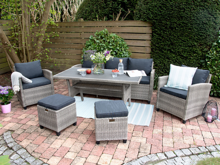Gartenmöbelset mit Wicker-Loungesesseln und Tisch im Garten.