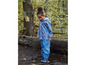 Ein Kind in einem blauen Regenmantel und einer Regenhose, die in einem Wald steht.