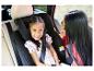 Mutter und Kind im Auto, Kind lächelt im Kindersitz, Mutter schaut Kind an.