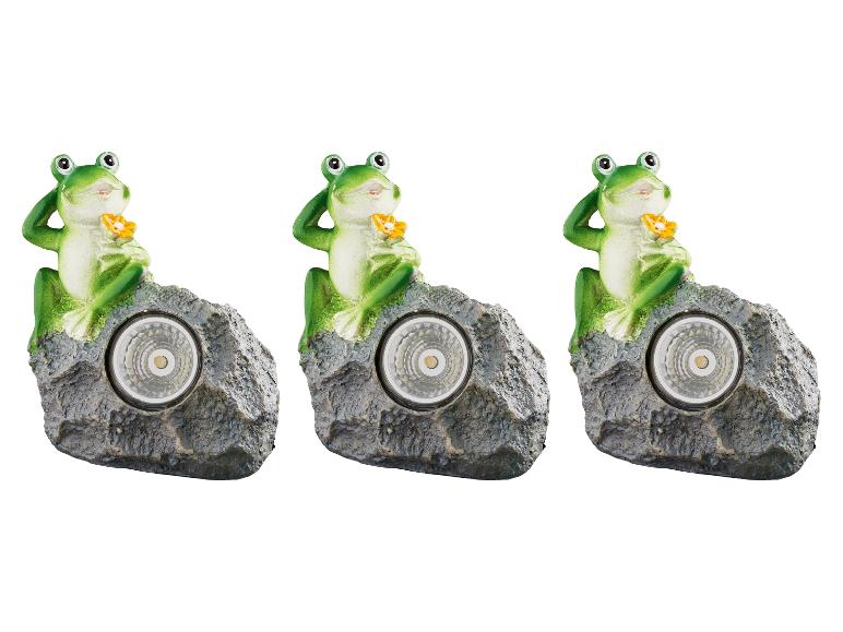 Drei Frosch-Solarleuchten auf Felsen.