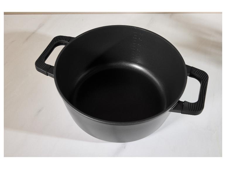 Schwarzer Kochtopf mit Griffen und Messmarkierungen auf weißer Oberfläche.