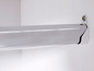 Eine verchromte Kleiderstange, die an einer weißen Wand befestigt ist.