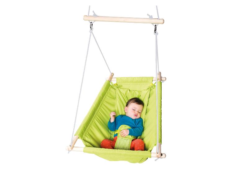 Ein Baby schläft in einer grünen Hängeschaukel mit Sicherheitsgurten.