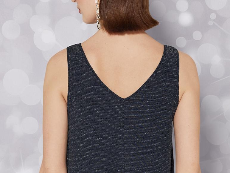 Weibliches Model trägt ein dunkelblaues Glitzertop.