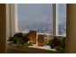 Fensterbank mit Weihnachtsdekoration: zwei hausförmige Kerzenhalter, Tannenzweige und Tannenzapfen.