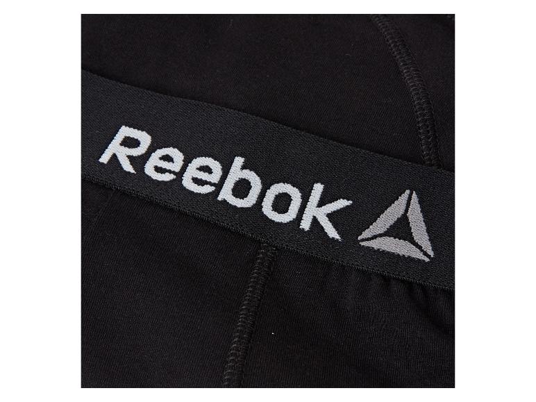 Schwarzes Gummiband mit weißem und grauem Reebok-Logo auf Kompressionsshorts.