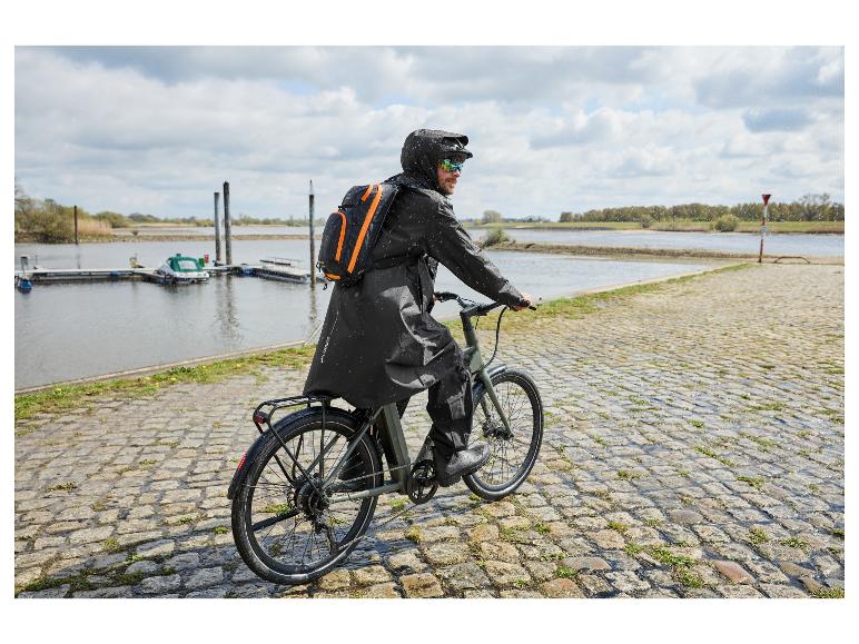 Mann auf einem Fahrrad im Regen trägt einen schwarzen CRIVIT Premium Regenponcho.