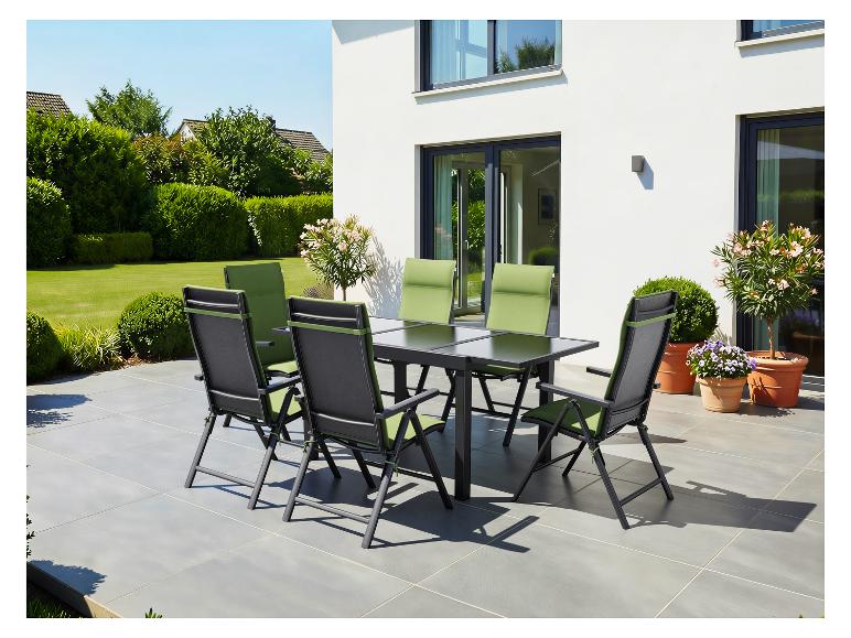 Terrassen-Essgruppe mit schwarzem Tisch und sechs Stühlen mit grünen Kissen auf einer gefliesten Terrasse.