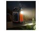 Tragbare Solar-Powerbank mit Taschenlampe und USB-Anschlüssen auf Holztisch bei Nacht