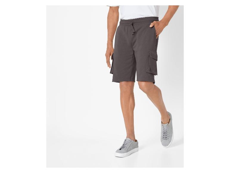 Herren Cargoshorts und graue Sneaker.