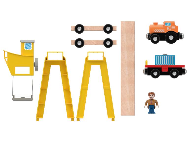 Holzspielzeug, darunter ein Kran, Eisenbahnschienen, Waggons und eine Figur.