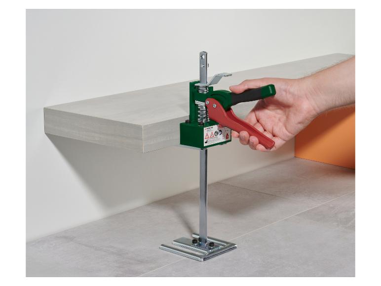 Person benutzt einen Parkside Fliesenheber, um ein hellgraues Regal zu justieren