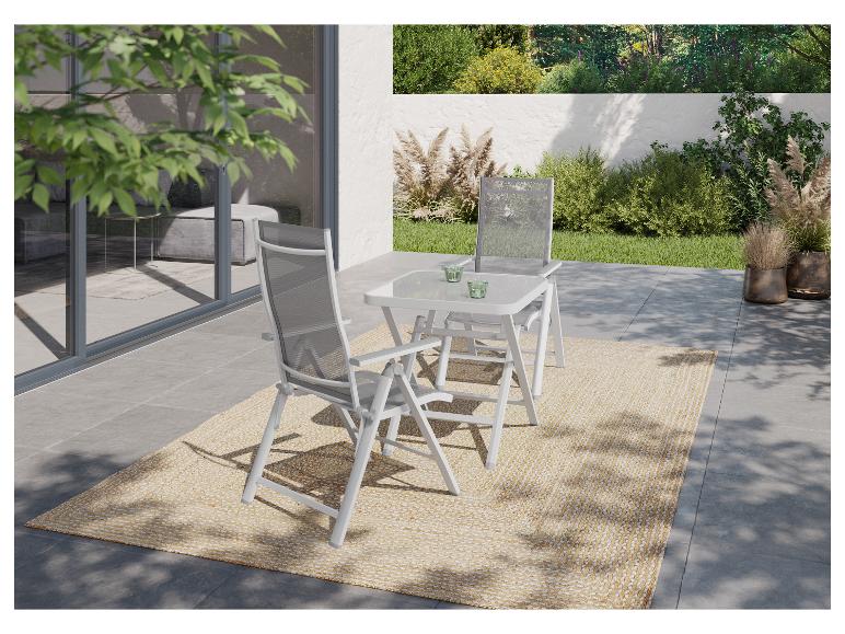 Garten-Essgruppe mit zwei Klappstühlen und einem Tisch auf einer Terrasse mit Teppich.