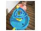 Junge gießt Wasser in blauen Wassertisch mit Spielzeug.