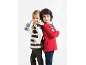 Zwei Kinder mit Walkie-Talkies, lächelnd und Rücken an Rücken stehend.