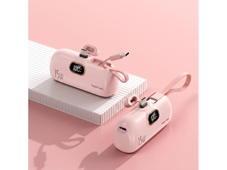 Zwei pinke 15W Powerbanks mit Digitalanzeigen, die 100% Ladung zeigen, auf rosa Hintergrund.