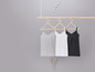 Drei basic Tanktops in Grau, Weiß und Schwarz an einem Holz-Kleiderbügel.