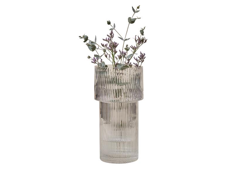 Gerippte Glasvase mit lila Blumen und Eukalyptus.
