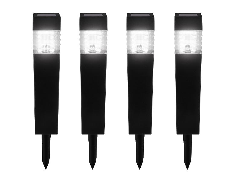 Vier schwarze Solar-Gartenleuchten mit weißem Licht und Erdspießen.