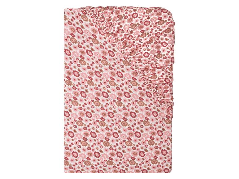 Spannbetttuch für Babybetten mit rosa-braunem Blumenmuster.