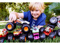 Ein Junge spielt mit Hot Wheels Monster Trucks im Gras.