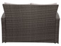 Eine graue Lounge-Garnitur aus Rattan mit beigefarbenen Kissen.