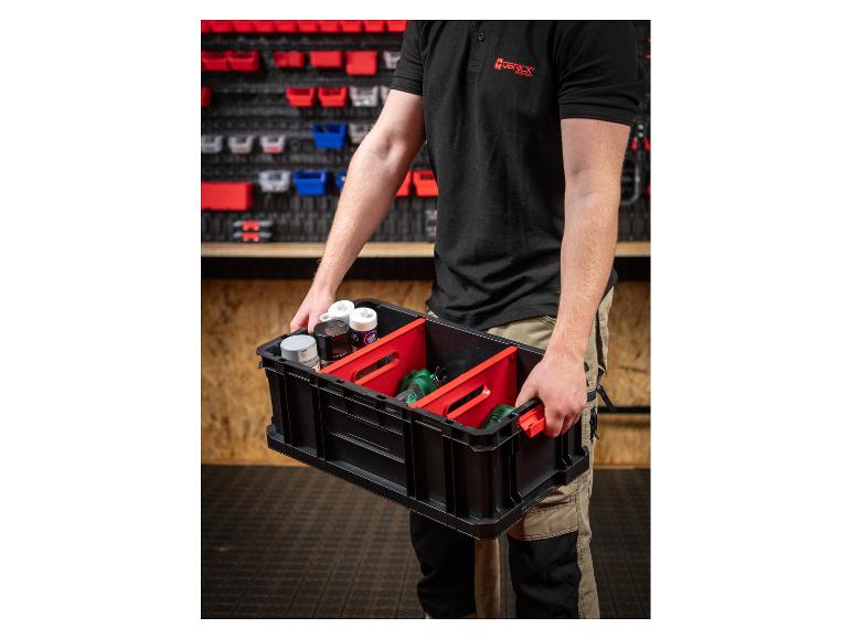 Mann hält eine schwarze Aufbewahrungskiste mit roten Trennwänden, gefüllt mit Werkzeugen und Sprühdosen.