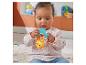 Ein sitzendes Baby spielt mit einer gelben und blauen Spielzeugrassel.