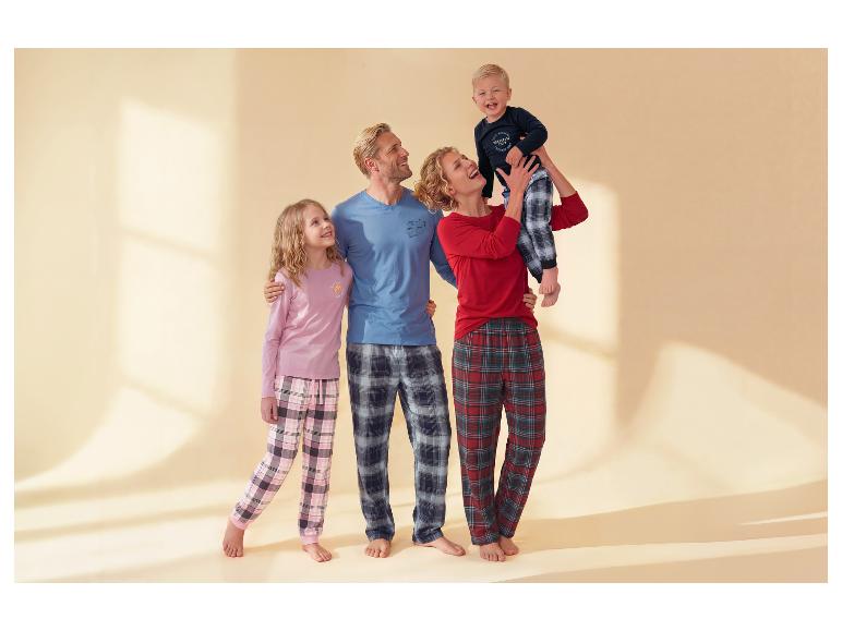 Familie in karierten Pyjamas: Vater und Tochter in Rosa, Mutter und Sohn in Rot.