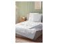 Weiße Steppdecke und Kissen auf einem Bett, Schlafzimmerinterieur mit grüner Wand.