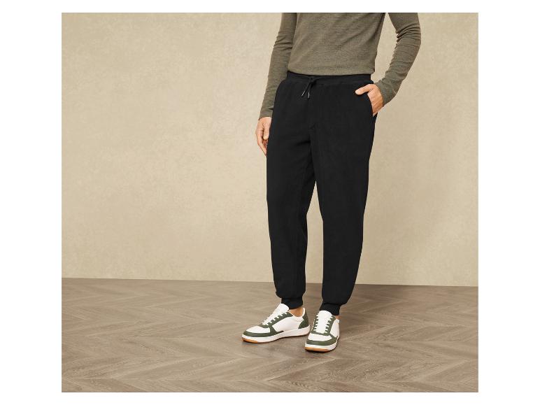 Schwarze Jogginghose mit weißen Sneakers.