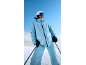 Skifahrerin im hellblauen Skianzug und Helm auf einem verschneiten Hügel.