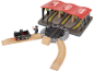 Holzeisenbahn-Set mit schwarzer Lokomotive, Lokführer und dreigleisigem Bahnhof.