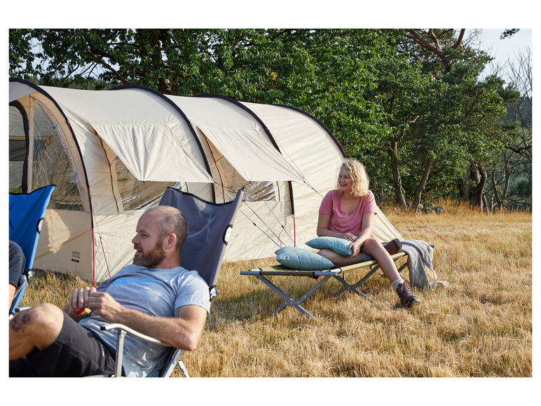 Zwei Personen entspannen im Freien, eine auf einem Stuhl und die andere auf einem Campingbett, neben einem Grand Canyon Zelt.