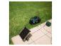 Mähroboter und Solarpanel auf Rasen und Pflaster.