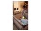 Mutter legt Baby in Reisebett mit leuchtendem Kuscheltier.