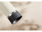 Cremefarbener Thermobecher mit dunkelgrauem Boden und Metallband.