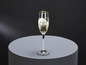 Ein Champagnerglas mit goldenem Rand auf einem grauen Untergrund.