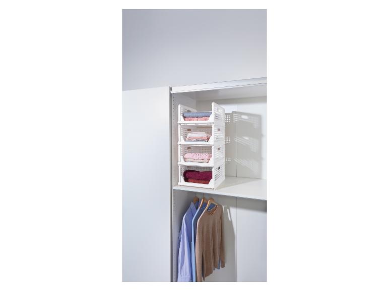 Weißes vierstöckiges Lagerregal gefüllt mit gefalteter Kleidung in einem Schrank.