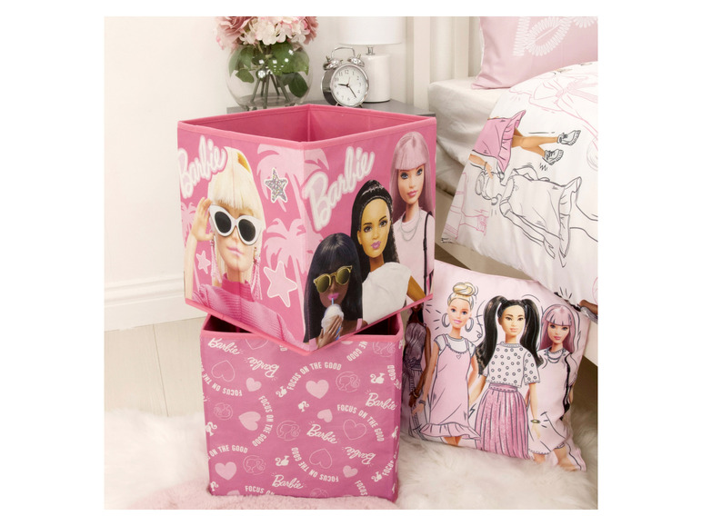 Zwei rosafarbene Aufbewahrungsboxen mit verschiedenen Barbie-Designs.