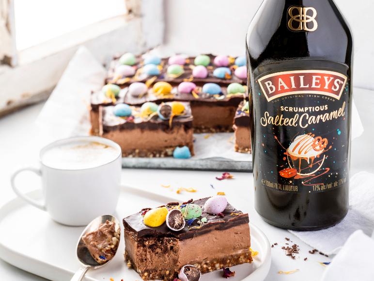 Karamelllikör, Schokoladenkuchen mit Ostereiern und Kaffee auf einem Tablett.