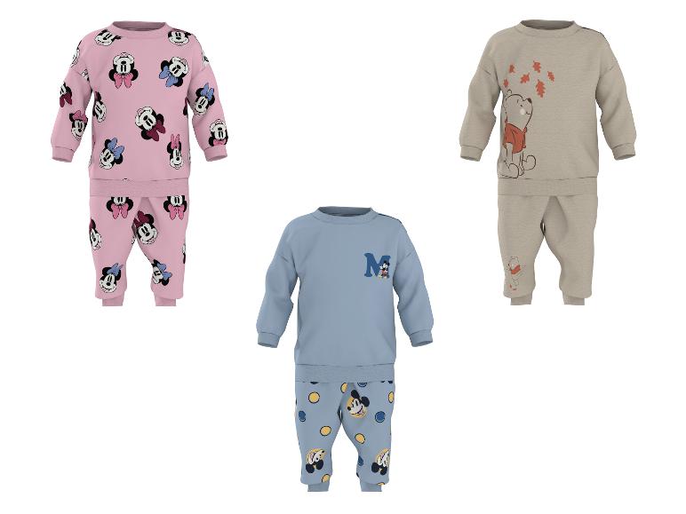 Kinderpyjamas mit Zeichentrickfiguren: ein rosa mit Minnie Maus, ein blau mit Mickey Maus und ein beige mit Winnie Puuh.