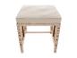 Outdoor-Bank mit cremefarbenem Kissen und Rattan-Untergestell.