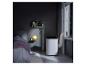 Mobiles Klimagerät im Schlafzimmer mit Bett, Nachttischlampe und Bücherregalen.